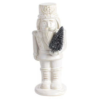 Mud Pie small white ceramic nutcracker holding a bottle brush tree
