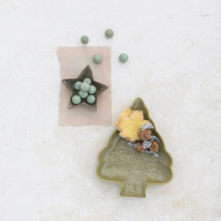 Green reactive glaze star plate holding a decorated holiday cookie