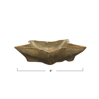 Styled view of small stoneware star shaped plate in reactive green glaze, each one unique