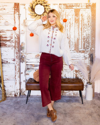 Back view of cable knit cardigan with floral embroidery and drop shoulders