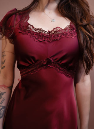 Detail view of lace-trimmed V-neckline on winter wine satin dress