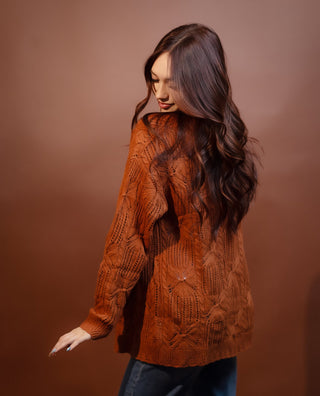 Close-up of rust cardigan cable knit and ribbed cuff detail