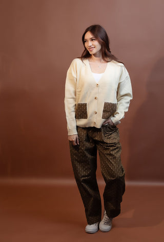 Close-up of earthy geometric woven patch pocket on cropped knit cardigan