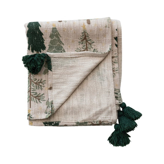 Close-up of evergreen tree print and black tassel on cotton throw