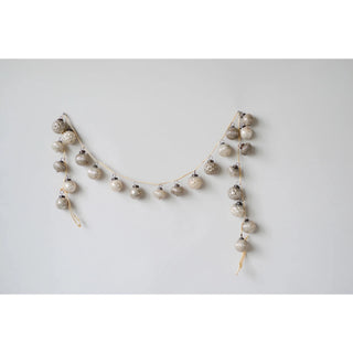 Close-up of embossed taupe and cream mercury glass ornaments on garland