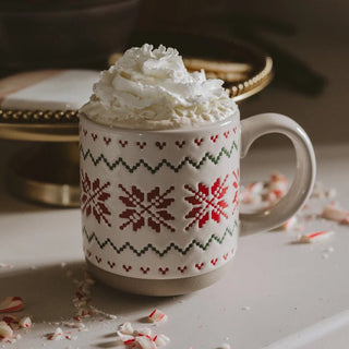 Cream stoneware coffee mug with embossed red and green Fair Isle sweater pattern