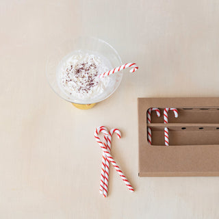 Close-up of red and white striped glass candy cane stir stick