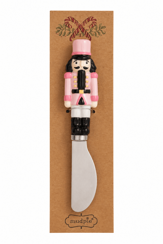 Styled view of Mud Pie nutcracker spreaders with hand-painted ceramic handles in wooden crate