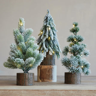 Styled view of Snow-tipped LED tabletop tree with frosted needles on faux wood slice base