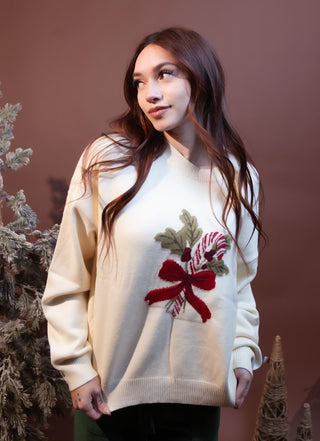 Styled view of ivory sweater with peppermint candy cane bow design for festive Christmas outings
