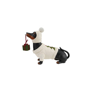 Resin black dachshund figurine in cream sweater and pom-pom hat holding present