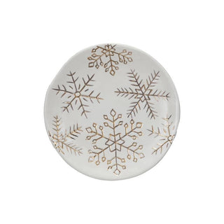 Detail view of gold snowflakes on creamy stoneware holiday plate
