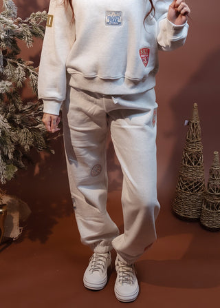 Close-up of vintage-inspired winter adventure patches on heather oat joggers