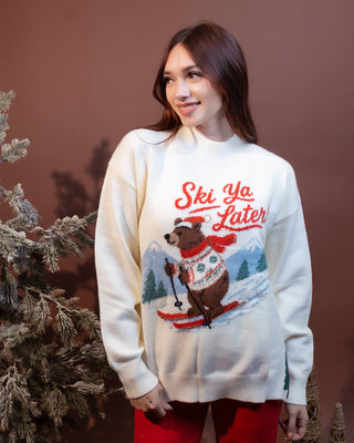 Styled view of soft knit mock neck sweater with Ski Ya Later skiing bear graphic