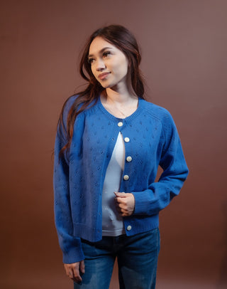 Back view of drop-shoulder eyelet knit cardigan with oversized button details
