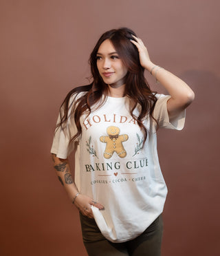 Styled view of ivory graphic tee with Holiday Baking Club print for festive baking days