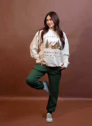 Close-up of festive lettering on ivory women's holiday sweater