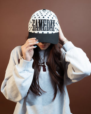 White canvas snapback cap with black polka dots and embroidered front design