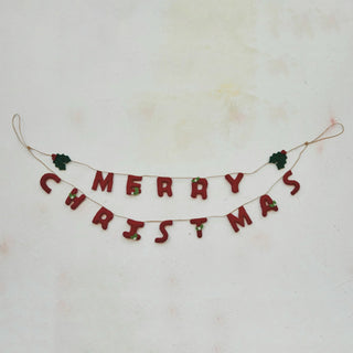 Close-up of red felt berries and holly leaves on Merry Christmas garland